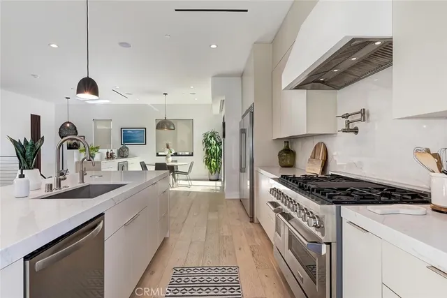 a kitchen with stainless steel appliances a sink a stove and cabinets