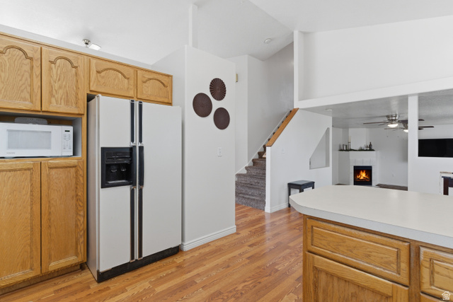 134 West 475 South Ogden, UT 84404 - Photo 27 of 27 Kitchen with a warm lit fireplace, white appliances, light countertops, light wood-style flooring, and open floor plan