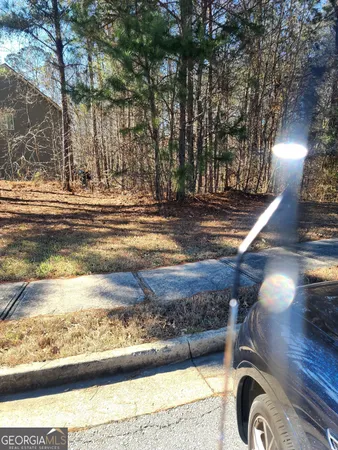 a backyard of a house with large trees and outdoor seating