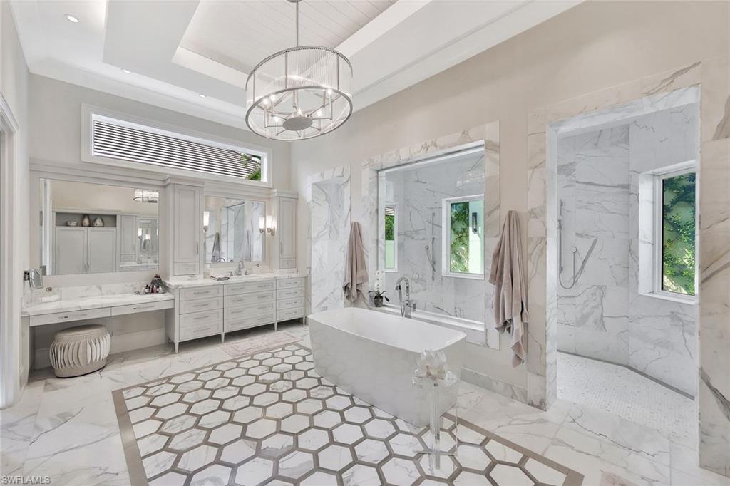 850 Nelson`s Walk Naples, FL 34102 - Photo 29 of 47 a large bathroom with a tub a double vanity sink a mirror and shower