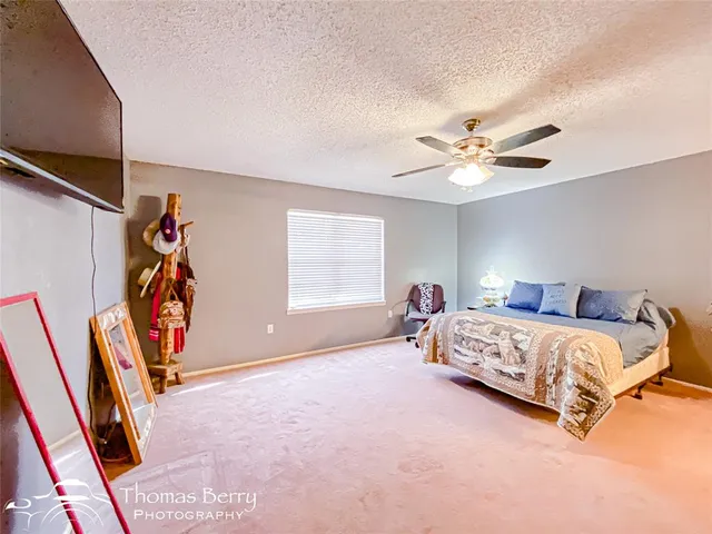 a spacious bedroom with a bed and a ceiling fan