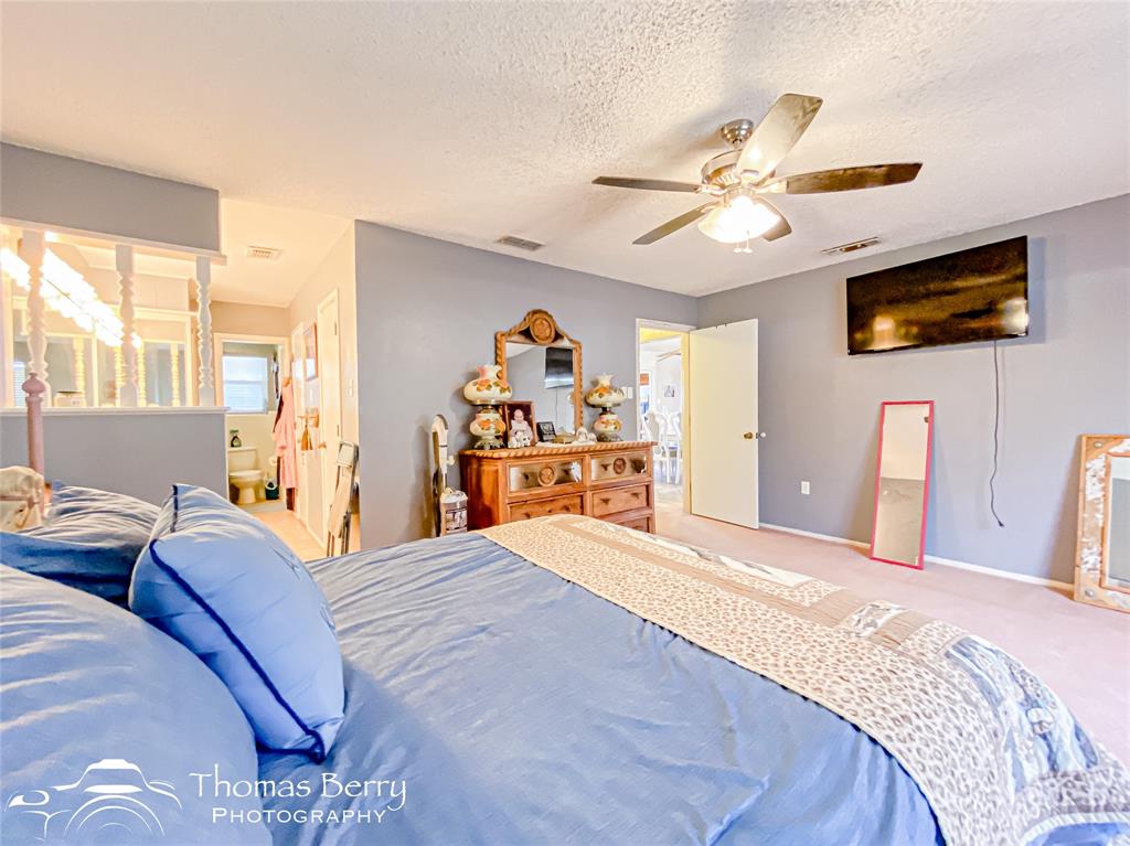 2732 County Road 248 Snyder, TX 79549 - Photo 14 of 31 a bedroom with a bed and a chandelier