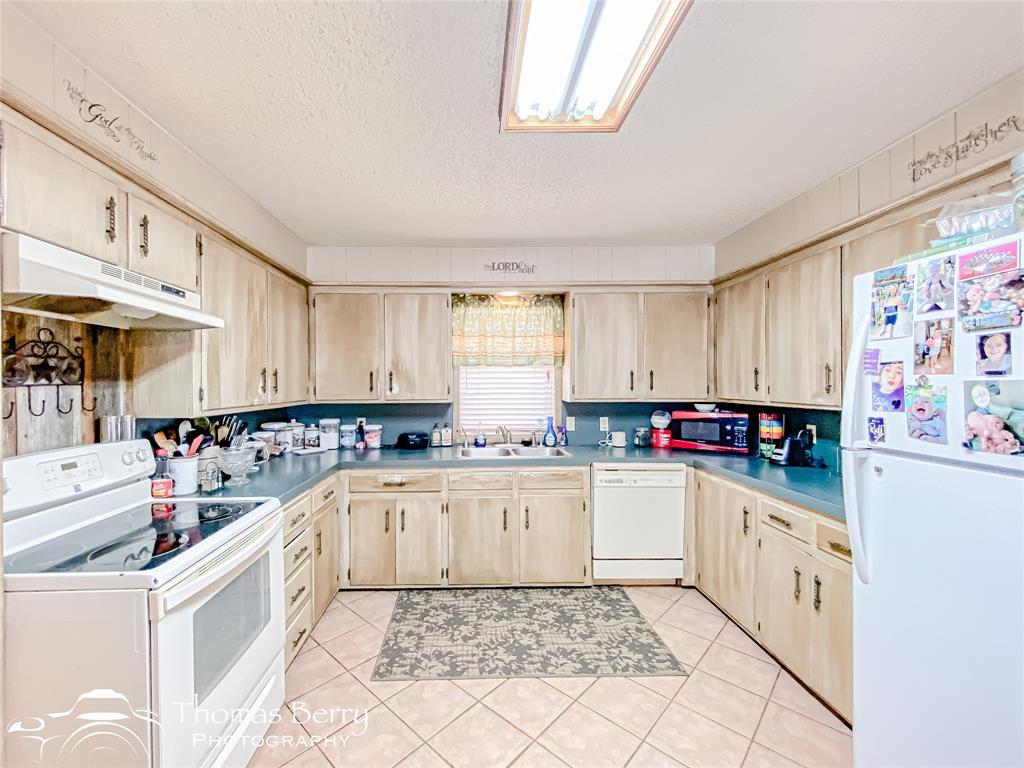 2732 County Road 248 Snyder, TX 79549 - Photo 6 of 31 a kitchen with a sink a stove and cabinets