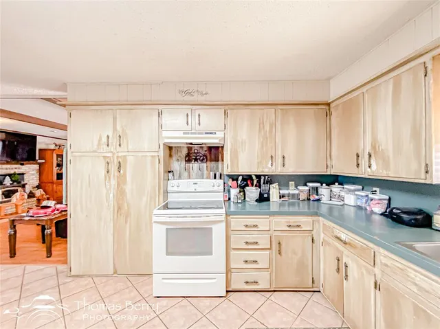 a kitchen with stainless steel appliances a stove and white cabinets