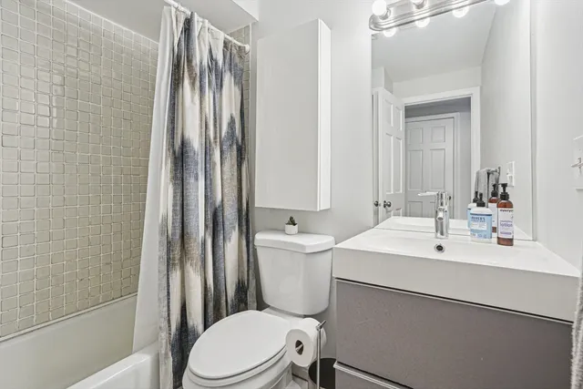 a bathroom with a sink a toilet a mirror and shower