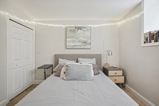 a bedroom with a bed and a painting on the wall