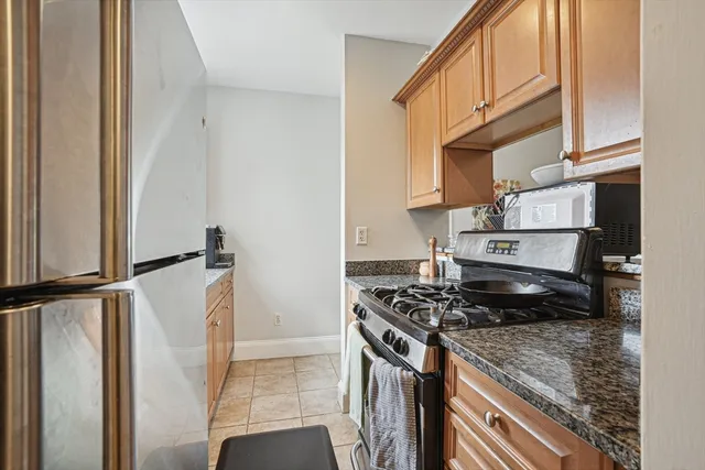 a kitchen with stainless steel appliances granite countertop a refrigerator a stove and a sink