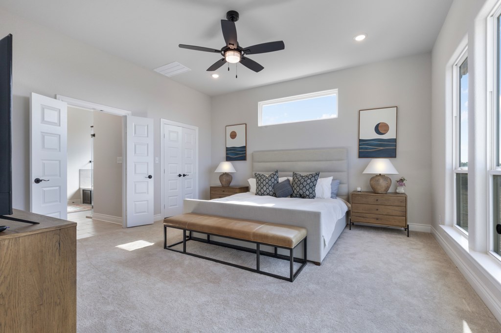 517 Dancing Sun Road Fredericksburg, TX 78624 - Photo 26 of 37 a spacious bedroom with a bed and a chandelier