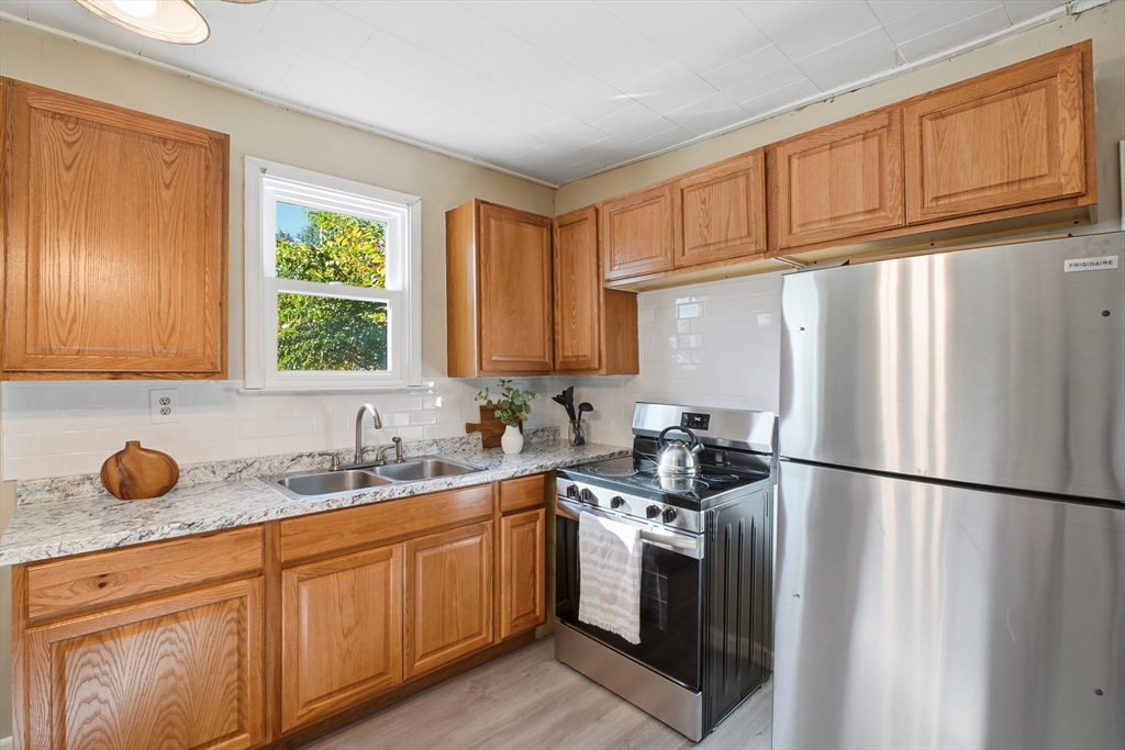 51-53 Abbe Avenue Springfield, MA 01107 - Photo 12 of 42 a kitchen with stainless steel appliances granite countertop a sink stove refrigerator and cabinets