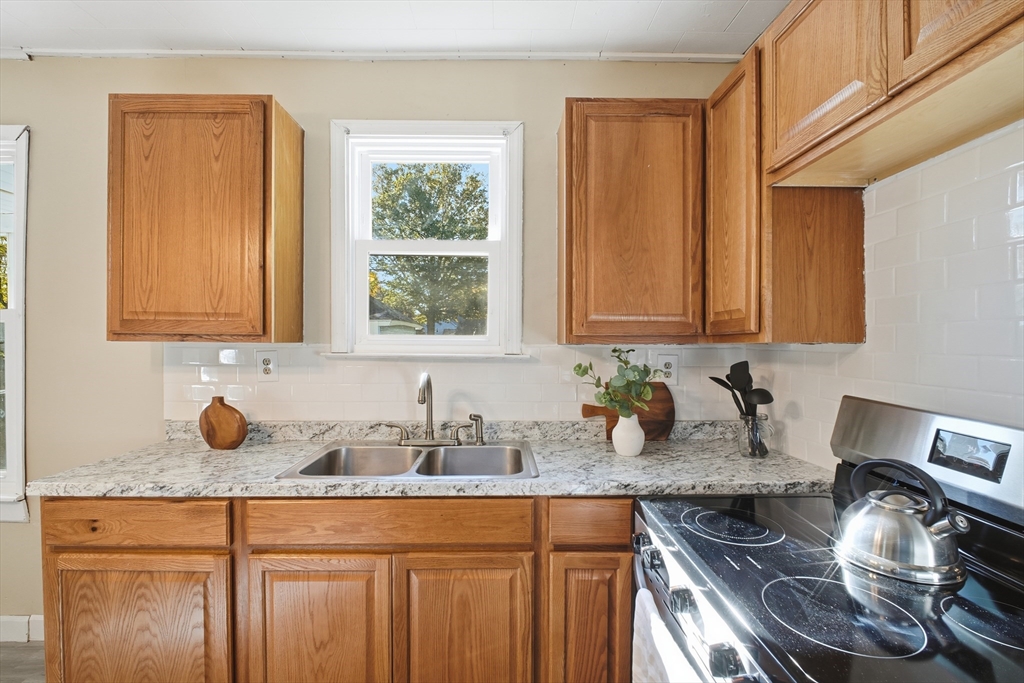 51-53 Abbe Avenue Springfield, MA 01107 - Photo 13 of 42 a kitchen with stainless steel appliances granite countertop a sink stove and cabinets