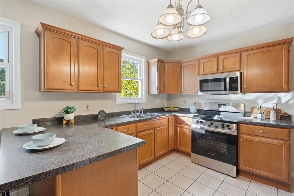 51-53 Abbe Avenue Springfield, MA 01107 - Photo 26 of 42 a kitchen with stainless steel appliances granite countertop wooden cabinets a stove a sink and dishwasher
