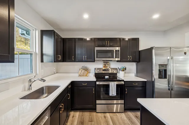 a kitchen with kitchen island granite countertop stainless steel appliances and sink