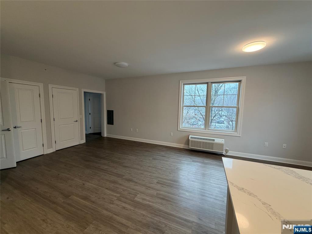 40 West Park Avenue, Unit 308 Park Ridge, NJ 07656 - Photo 2 of 9 an empty room with wooden floor and windows