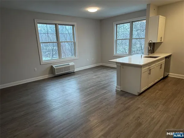an empty room with wooden floor and a window