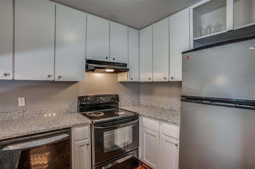 982 South Weatherred Drive, Unit B Richardson, TX 75080 - Photo 5 of 13 Kitchen featuring black appliances, under cabinet range hood, white cabinetry, and light stone counters