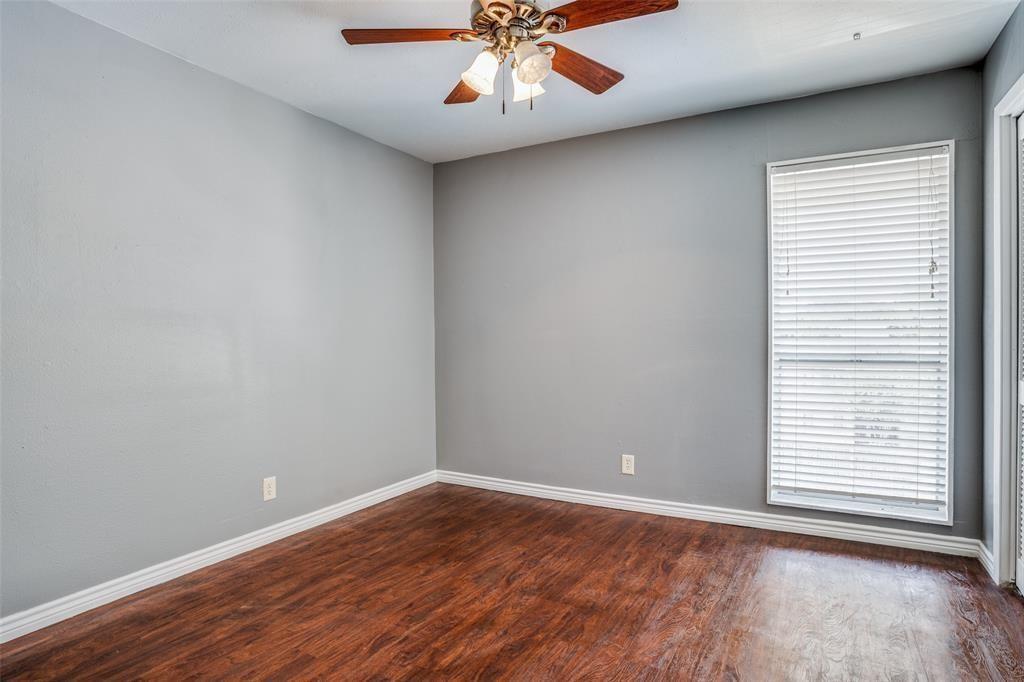 982 South Weatherred Drive, Unit B Richardson, TX 75080 - Photo 9 of 13 Empty room with dark wood-style floors and ceiling fan