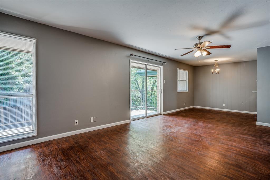 982 South Weatherred Drive, Unit B Richardson, TX 75080 - Photo 10 of 13 Empty room featuring wood finished floors, a chandelier, and ceiling fan