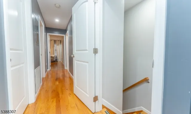 a view of a hallway with wooden floor and staircase
