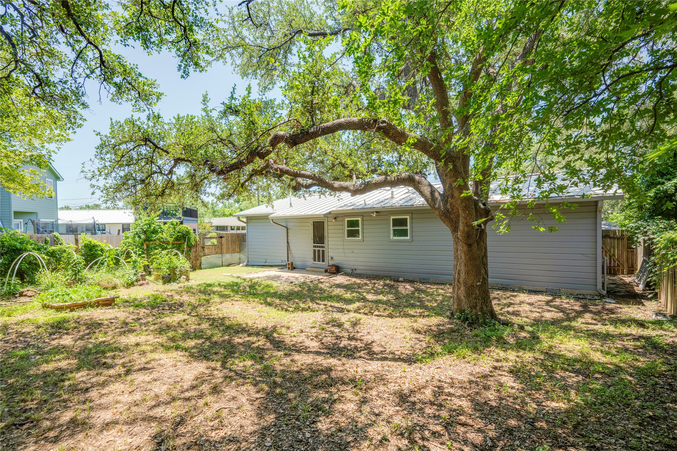 1707 Overhill Drive Austin, TX 78721 - Photo 35 of 36 A spacious yard with mature shade trees, offering ample room for outdoor activities and gardening.