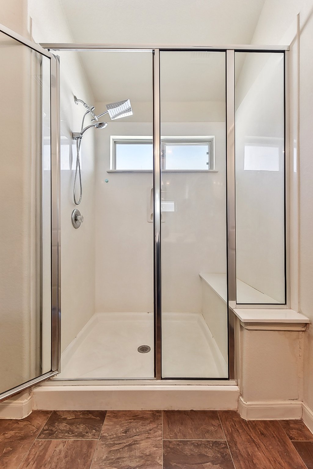 310 Potters Peak Way Georgetown, TX 78626 - Photo 4 of 21 Glass-enclosed shower with a built-in bench, two shower heads, and two privacy windows