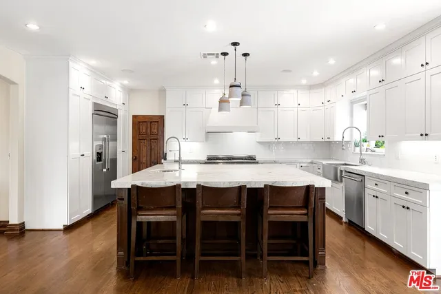 a large kitchen with kitchen island a sink stainless steel appliances and cabinets