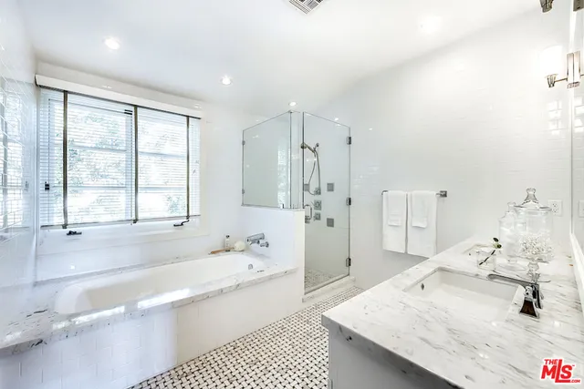 a en suite bathroom with a double vanity sink a large mirror and shower