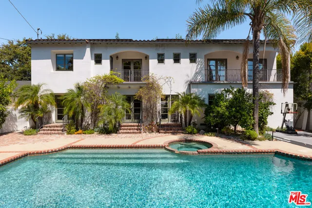 a front view of a house with swimming pool having outdoor seating