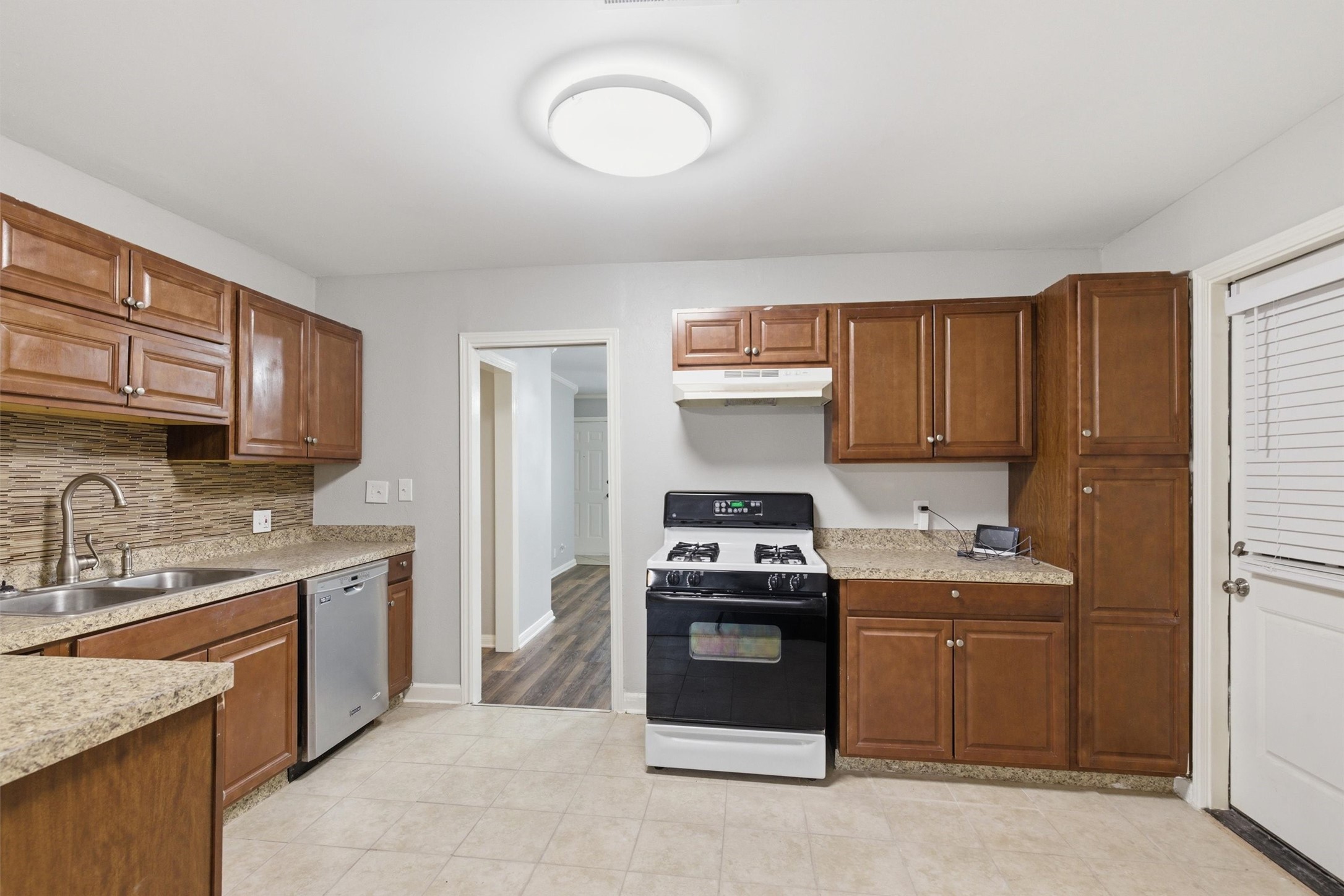 3615 Alberta Street Houston, TX 77021 - Photo 5 of 16 a kitchen with stainless steel appliances granite countertop a stove a sink dishwasher and a refrigerator with wooden cabinets