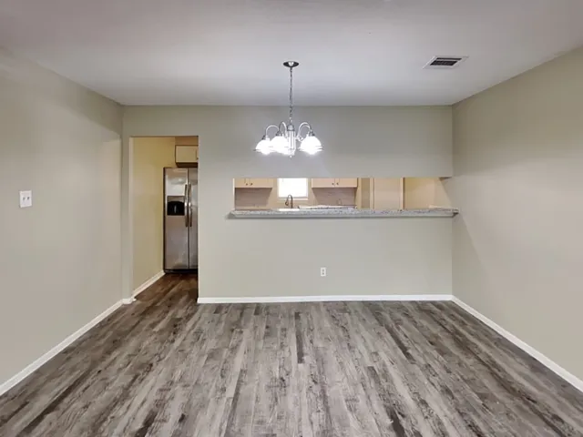 a view of a room with wooden floor and chandelier