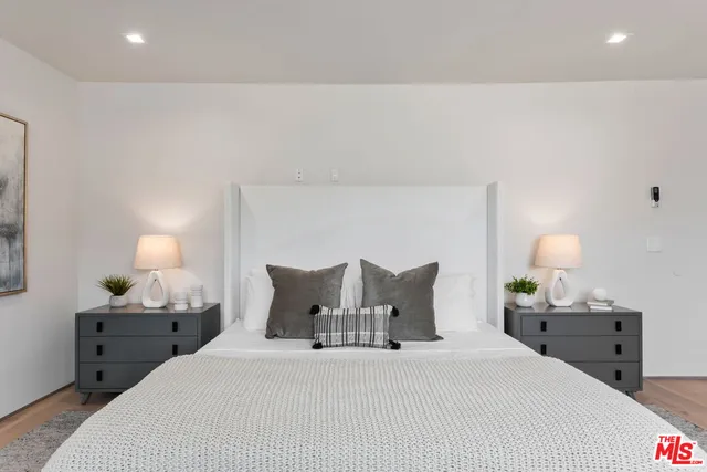 a bedroom with a bed and a lamp on dresser