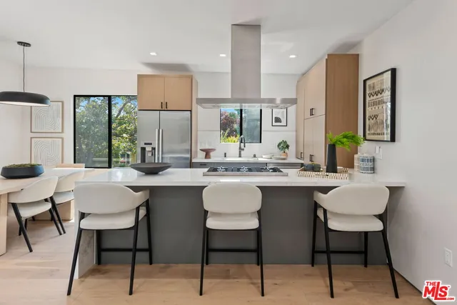 a kitchen with a sink and chairs