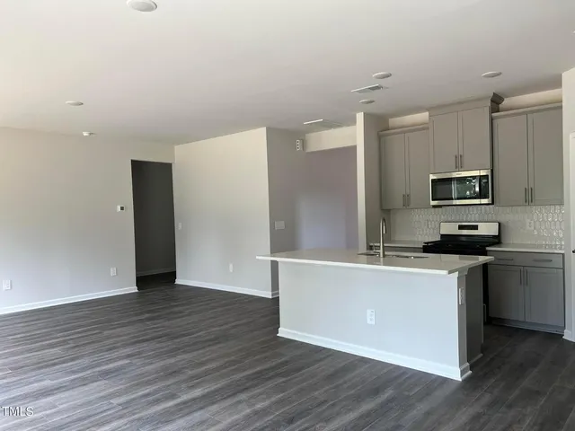 a kitchen with stainless steel appliances a refrigerator sink and microwave