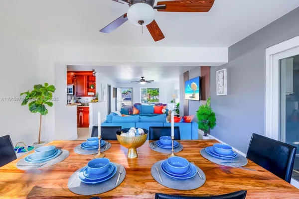 a living room with furniture kitchen view and a large window