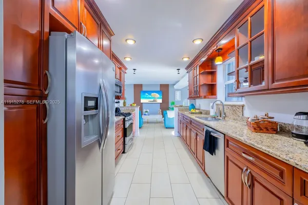 a kitchen with stainless steel appliances granite countertop a stove top oven a sink and cabinets
