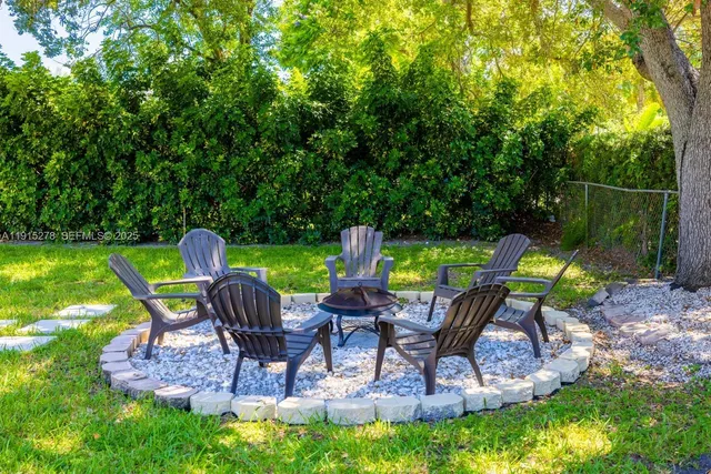 a view of a swimming pool with seating area and garden in the back