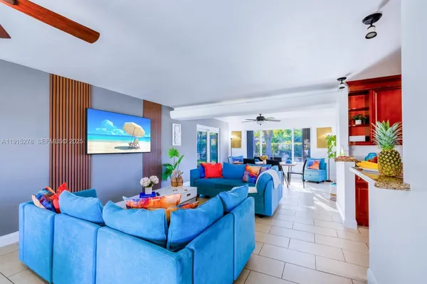 a living room with blue lights with furniture and a potted plant