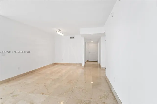 a view of a living room hardwood floor and a kitchen