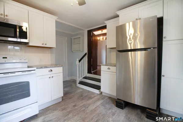 a kitchen with stainless steel appliances white cabinets and a refrigerator