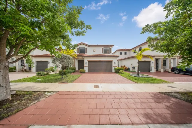 a front view of a house with a yard and a garage