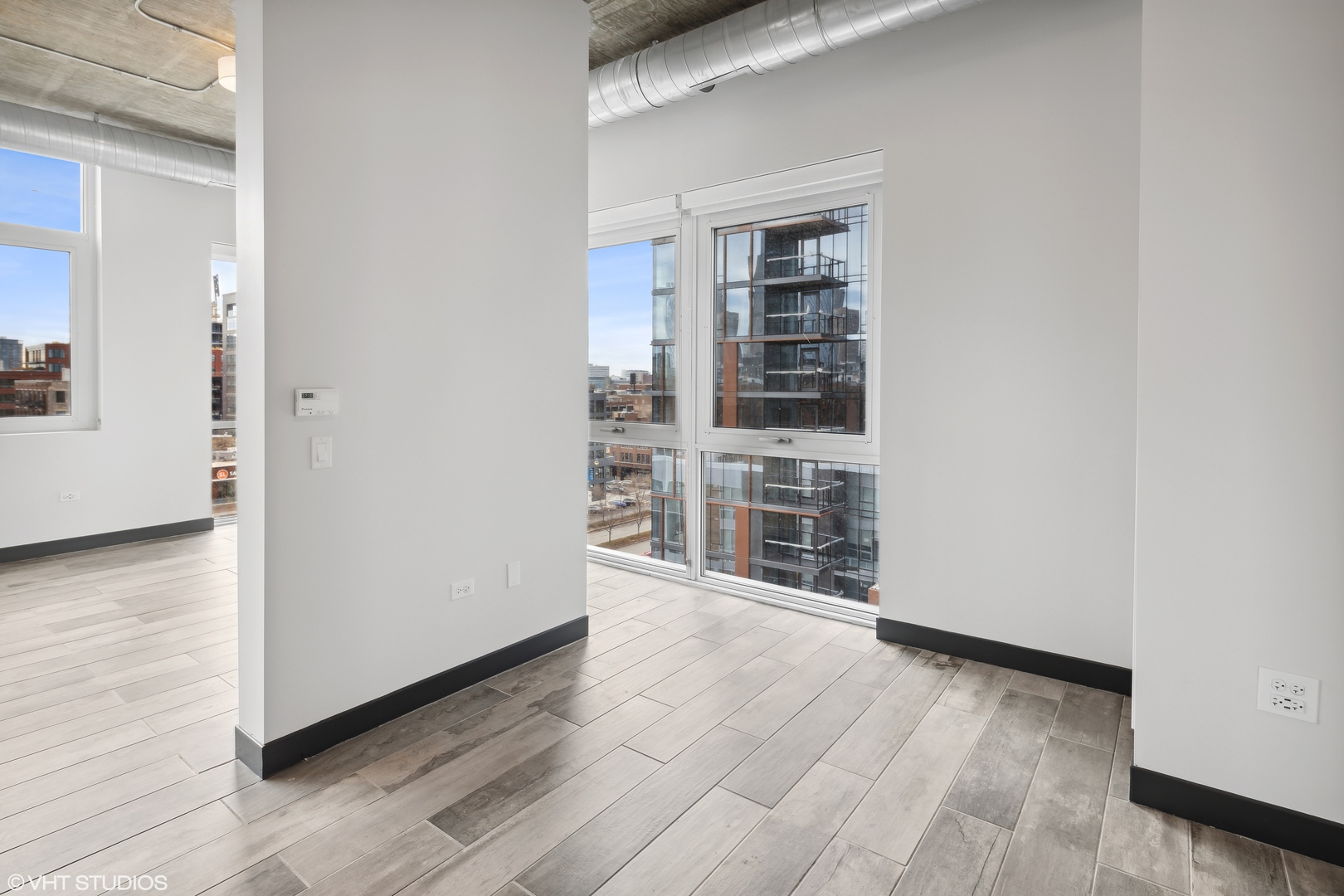 171 North Aberdeen Street, Unit 912 Chicago, IL 60607 - Photo 8 of 21 an empty room with wooden floor and windows