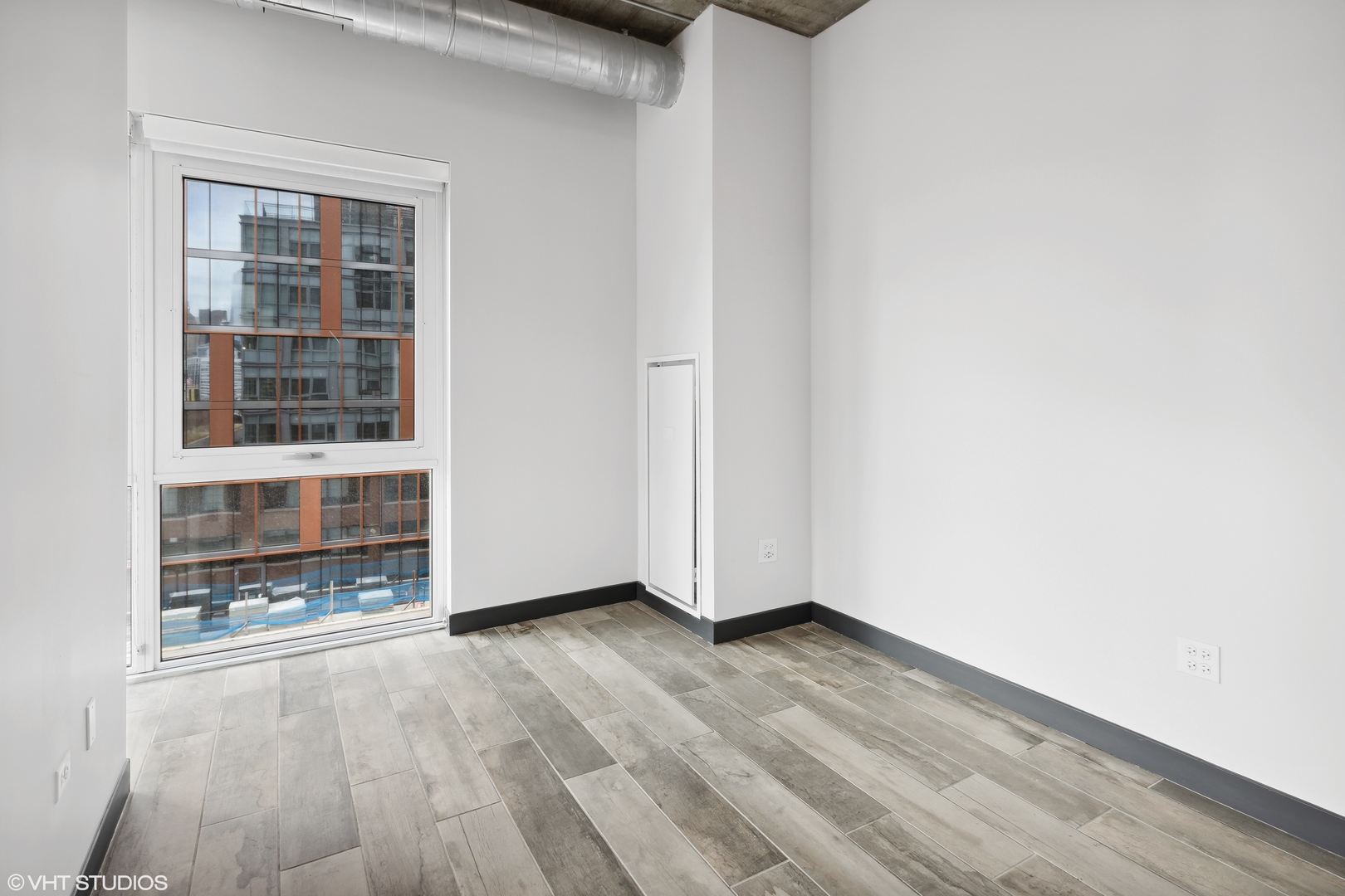 171 North Aberdeen Street, Unit 912 Chicago, IL 60607 - Photo 9 of 21 an empty room with wooden floor and windows
