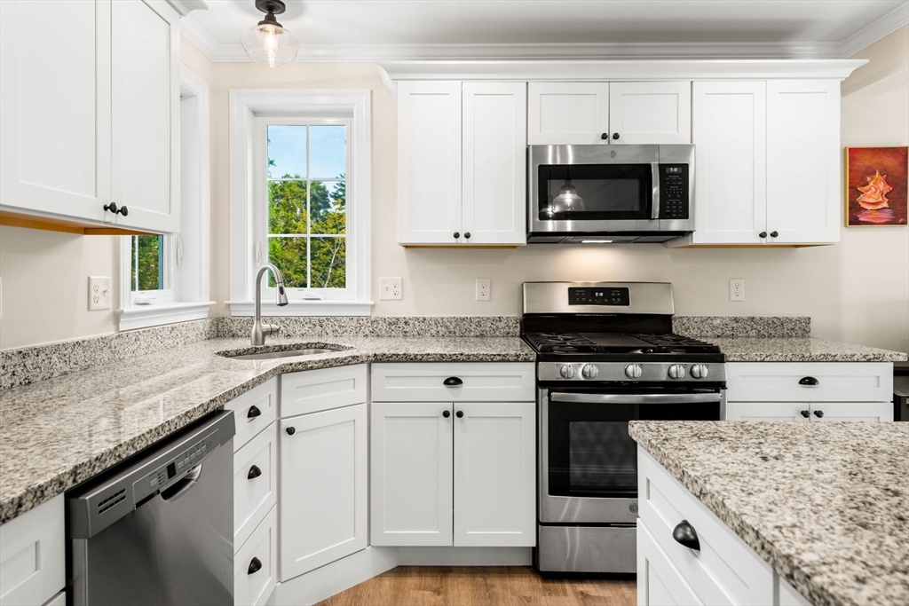 84 Ferry Road Salisbury, MA 01952 - Photo 5 of 42 a kitchen with granite countertop a stove sink and microwave