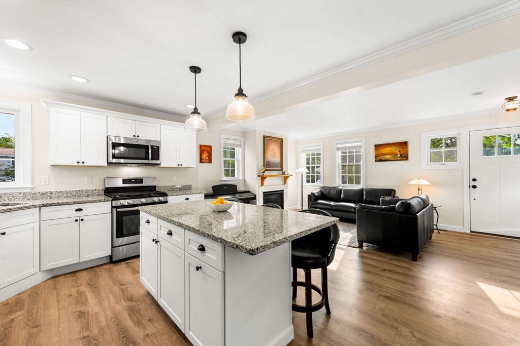 84 Ferry Road Salisbury, MA 01952 - Photo 6 of 42 a open kitchen with stainless steel appliances granite countertop a stove top oven a sink dishwasher a dining table and chairs with wooden floor