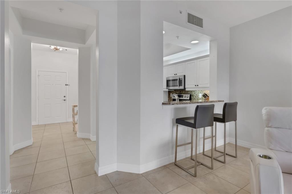 401 Bayfront Place, Unit 3207 Naples, FL 34102 - Photo 11 of 22 Hall featuring light tile patterned flooring and a tray ceiling