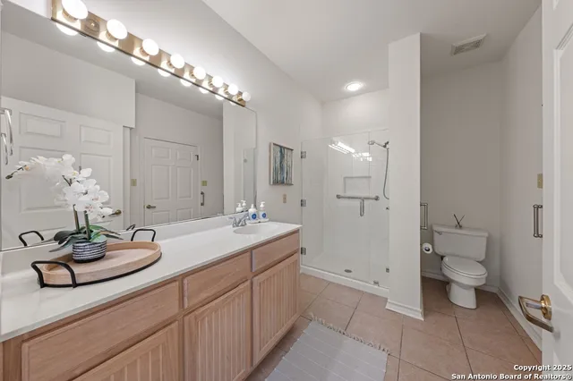 a spacious bathroom with a granite countertop sink a toilet and a mirror