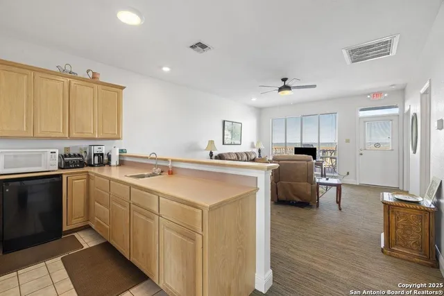 a large white kitchen with sink and cabinets