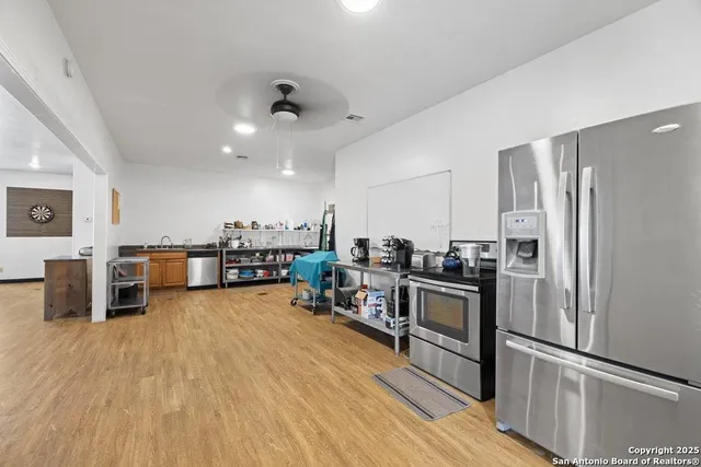 a kitchen with stainless steel appliances a stove a refrigerator and wooden floor