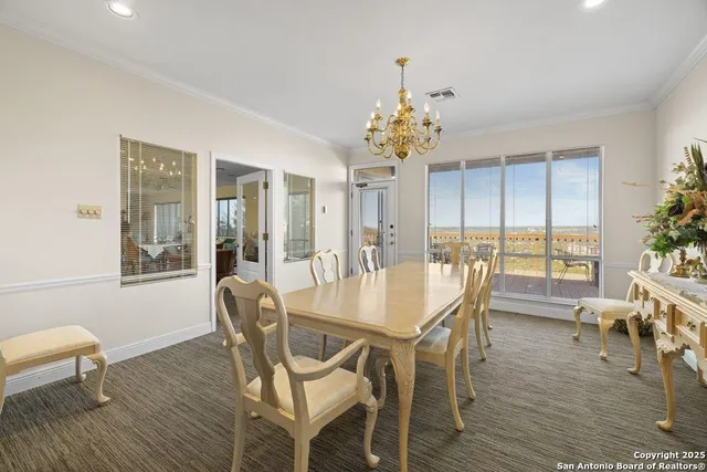 a dining room with furniture a chandelier and wooden floor