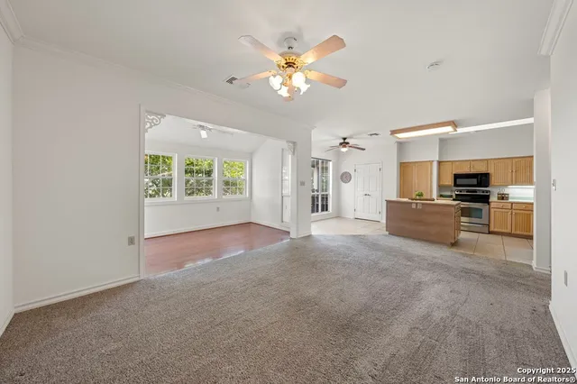 a view of a livingroom with a ceiling fan a flat screen tv and a ceiling fan