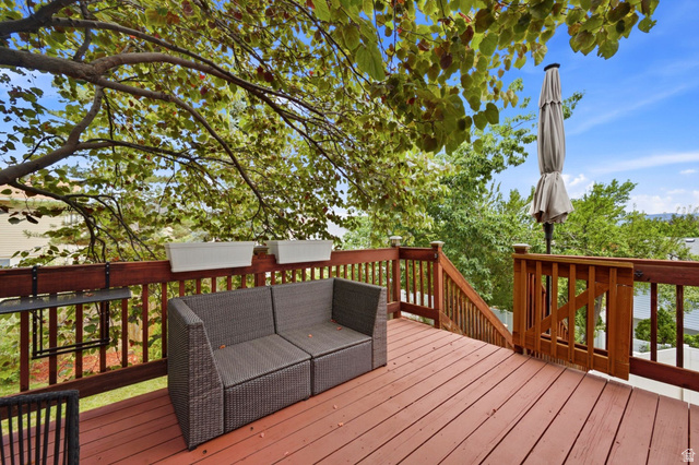 1112 Eagle Ridge Circle Sandy, UT 84094 - Photo 29 of 38 Expansive wood deck with rich red-brown stain, featuring a full wood railing system and a gate